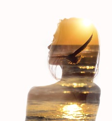Double exposure portrait of a young woman combined with photograph of flying bird in sunset reflecting in ocean. Conceptual image showing unity of human with nature. Ecology, freedom, environment