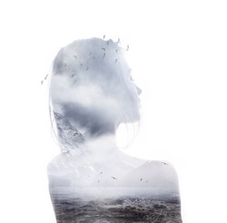 Double exposure portrait of young thoughtful woman combined with photograph of ocean with mountains and flying birds. Conceptual image showing unity of human with nature. Ecology, freedom, environment