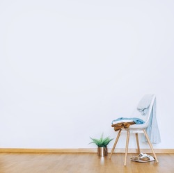 Indoors flat wall mockup with green potted houseplant and Clothes over Chair in minimalist style. Earthy Neutrals Tones Background. Interior in airy light style with wooden floor