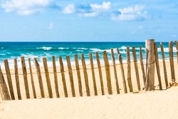 Wooden fence on an Atlantic beach in France, The Gironde Department. Shot with a selective focus