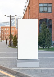 Blank white vertical pylon stand mock up brick building background. Empty vertical signplate for commercial advertising mockup. Clear urban banner or pointer mokcup template.