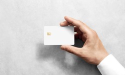 Hand holding blank white credit card mockup with rounded corners. Plain creditcard mock up template with electronic chip holding arm. Plastic bank-card display front design. Business branding.