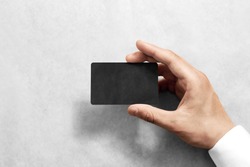 Hand hold blank black craft card mockup with rounded corners. Plain kraft call-card mock up template holding arm. Hand made namecard display front. Check offset card design. Business branding.