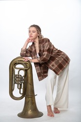 A girl poses with a brass musical instrument tuba