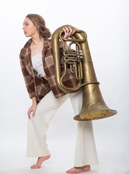 A girl poses with a brass musical instrument tuba