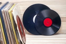 Vinyl record in front of a collection of albums, vintage process. Copy space for text.