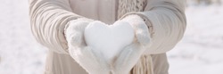 Snow heart in hands. Human hands in warm beige gloves with snowy heart. I love winter or St.Valentine's Day romantic creative concept.