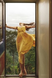 Travel and Exploration of Tourist Woman by Train to Famous Landmarks in Sri Lanka. Romantic young traveler woman enjoying extreme fun train ride from Ella to Kandy among tea plantations in the