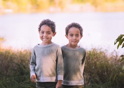 Environmental portrait of cute African American twin boys: Midwestern lake in background