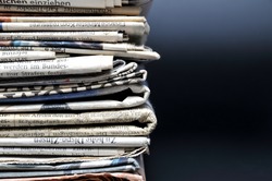 Stack of newspapers on black background