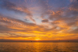 Beautiful sunset over the sea water on the island of Koh Phangan, Thailand. Travel and nature concept. Evening sky, clouds, sun and sea water
