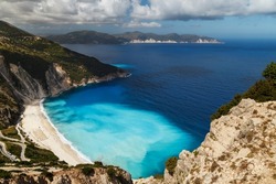 A top view at Myrtos Beach and fantastic turquoise and blue Ionian Sea water. Aerial view, summer scenery of famous and extremely popular travel destination in Cephalonia, Greece, Europe.