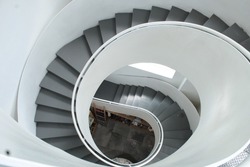 Image of some spiral stairs inside a museum with white tones.