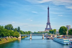 View of the Eiffel Tower from the Seine, with a view of a bridge in panoramic view.