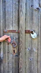 Old locked wooden door with antique padlock and lock.