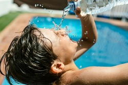 Heat wave. Splashing pouring spilling throwing water in the face with a bottle due to high temperatures in summer. Pool and water to withstand the heat wave during the holiday season. heat stroke from