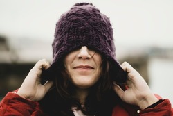 pull head wool cap autumn winter casual woman wearing wool hat outdoors hiding her eyes under fashion knitted cap. Winter wool hat and septum piercing. hat for the cold. Protect hair the cold