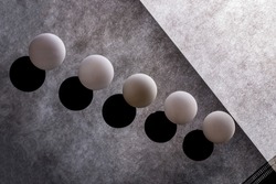 Abstract still life with white balls on a reflective surface