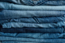 Stack of a stack of old jeans various shades of blue jeans. Denim jeans texture. Denim background texture for design. Canvas denim texture. Blue denim background.