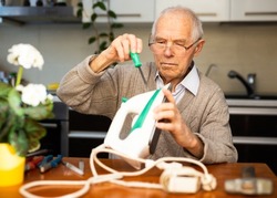 an elderly gentleman is fixing an iron