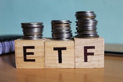Wooden block with a ETF word on stacked coins - Business Concept, Wooden block with a ETF word on stacked coins