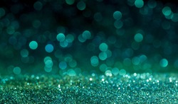 green Sparkling Lights Festive background with texture. Abstract Christmas twinkled bright bokeh defocused and Falling stars. Winter Card or invitation.