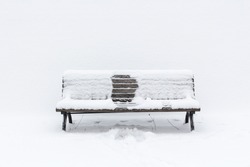 snow-covered wooden bench with an imprint of someone, who had been sitting in the middle; it seems, it was winter and she has gone