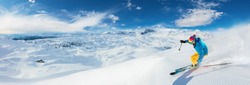 Alpine skier skiing downhill, panoramic format. Winter sports and leasure activities