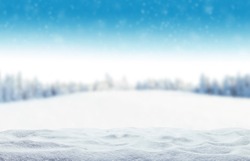 Winter background with pile of snow and blur landscape. Copyspace for text