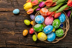 Easter eggs and tulips on wooden planks