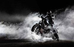 High power motorcycle chopper with man rider at night. Fog with backlights on background.
