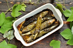 small fish in grape leaves baked as dolma. Mediterranean dish. popular in Greece and Turkey. Fish nawaga baked recipe becomes juicy. usually cooked like mackerel and other small fish.