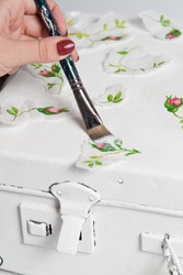 technique decoupage.  the decor of the old suitcase. decorating objects with paper napkins with a pattern. A ready-made drawing is used and an appliqué is made. hobbies and interests.