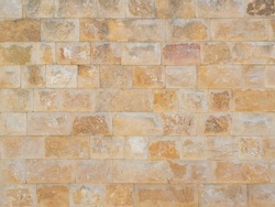 Travertine masonry texture. Facade cladding. Wall with orange rough masonry. Full screen photo. Not seamless texture