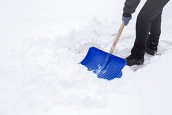 Man cleaning snow with shovel in winter day.
