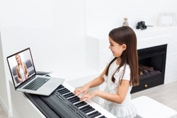 Scene of piano lessons online training or E-class learning while Coronavirus spread out or covid-19 crisis situation, vlog or teacher make online piano lesson to teach students pupils learn from home.