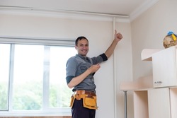 A handyman installing new cornice for curtains, home repair and renovation works