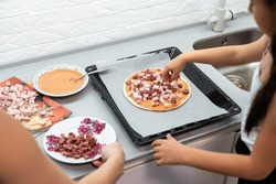 little girl makes pizza at home