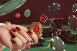 Bitcoin gold coin with poker chips on a green poker table against black background. Blockchain casino. Online gambling