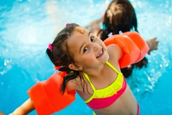 Swimming pool slides for children on water slide at aquapark . Summer kid holiday outdoor. Little girl in aqua park.