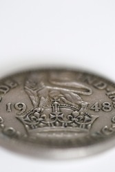 Macro close-up on one schilling british coin from 1948 on white background with copy space and narrow depth of field