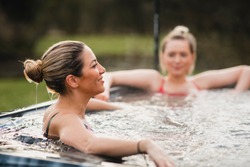 Mid adult woman relaxing in a hot tub with her friends.