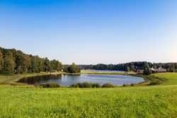 Lake Kaussjärv in Võru county, Estonia. Small lake, green grass.