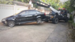 Blurred a police department tow truck are towing black vehicle are accident on the road to prevent the danger of accidental duplications and delivers to the garage