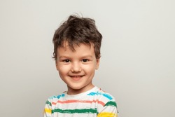 Beautiful kid boy wearing casual t-shirt standing over isolated white background with funny face. 