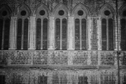 Old huge gothic building wall. Tall windows. Brickwork.