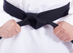 Closeup of a martial arts man tying his black belt
