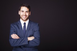 Happy smiling business man with crossed arms on black background