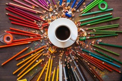 color pencil and a cup of coffee on wooden background