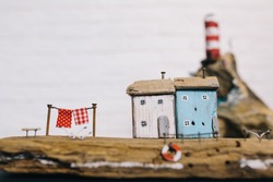two miniature house, and the background blurred miniature lighthouse on a cliff